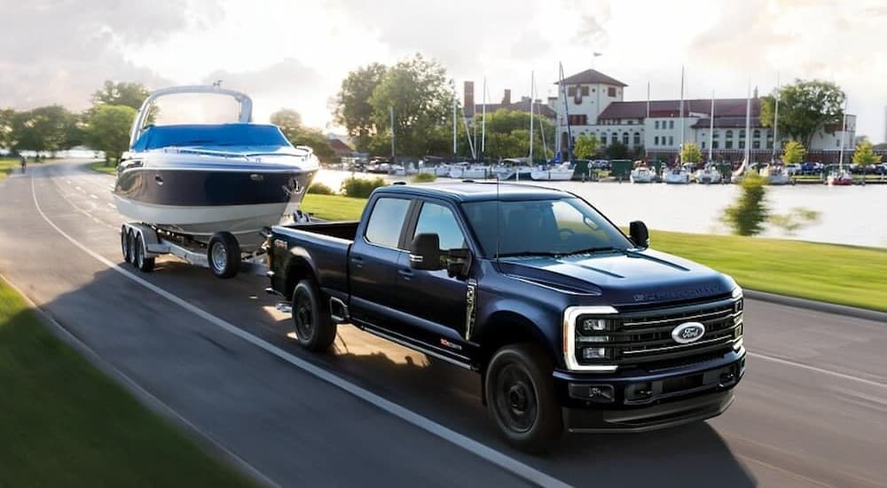 A black 2026 Ford F-350 Super Duty towing a boat.