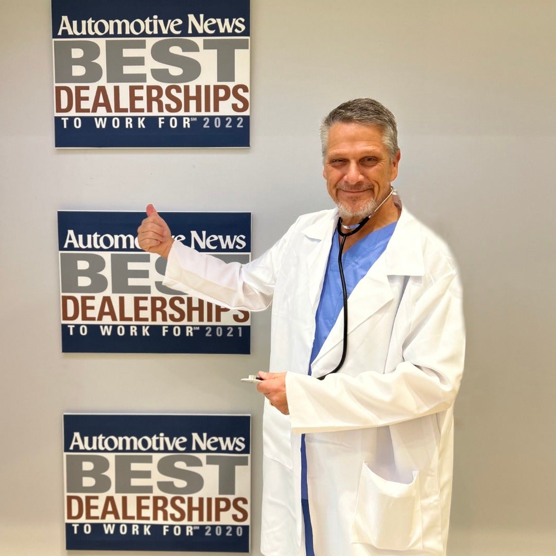 credit doctor next to a Automotive News Best Dealership sign