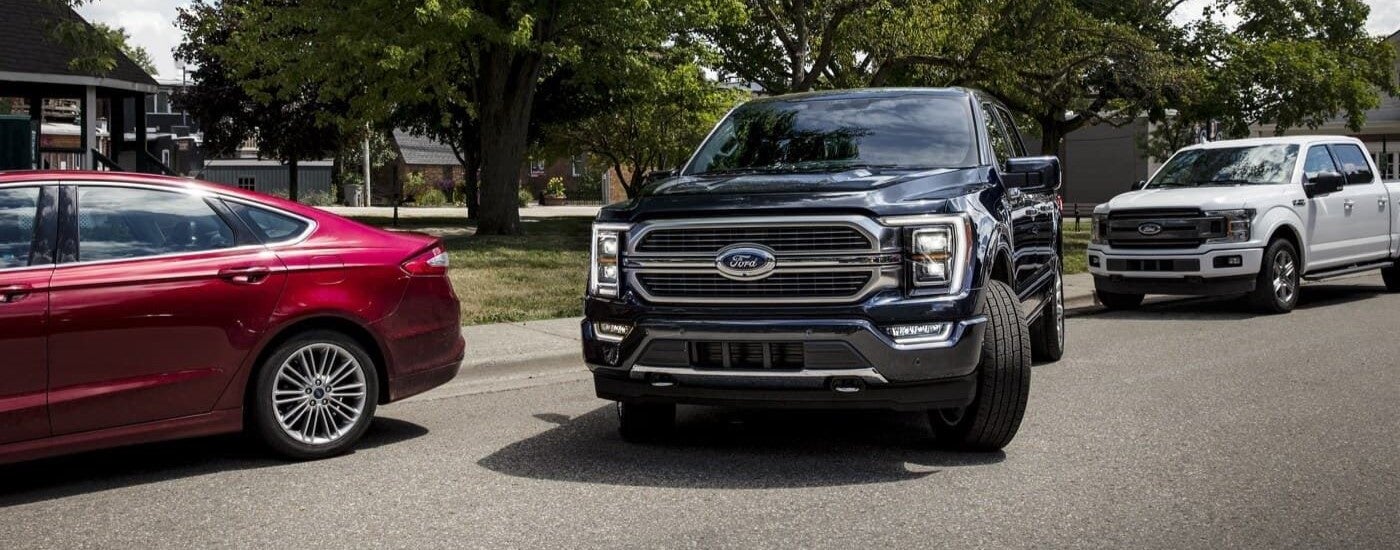 Black 2023 Ford F-150 pulling away from a curb.