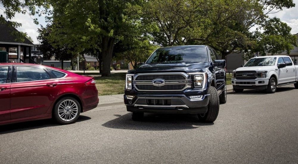 Black 2023 Ford F-150 pulling away from a curb.