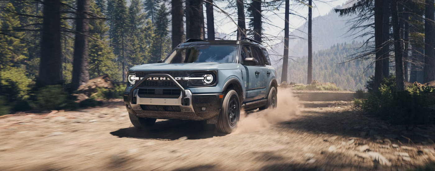 Blue 2025 Ford Bronco Sport Outer Banks driving down a trail