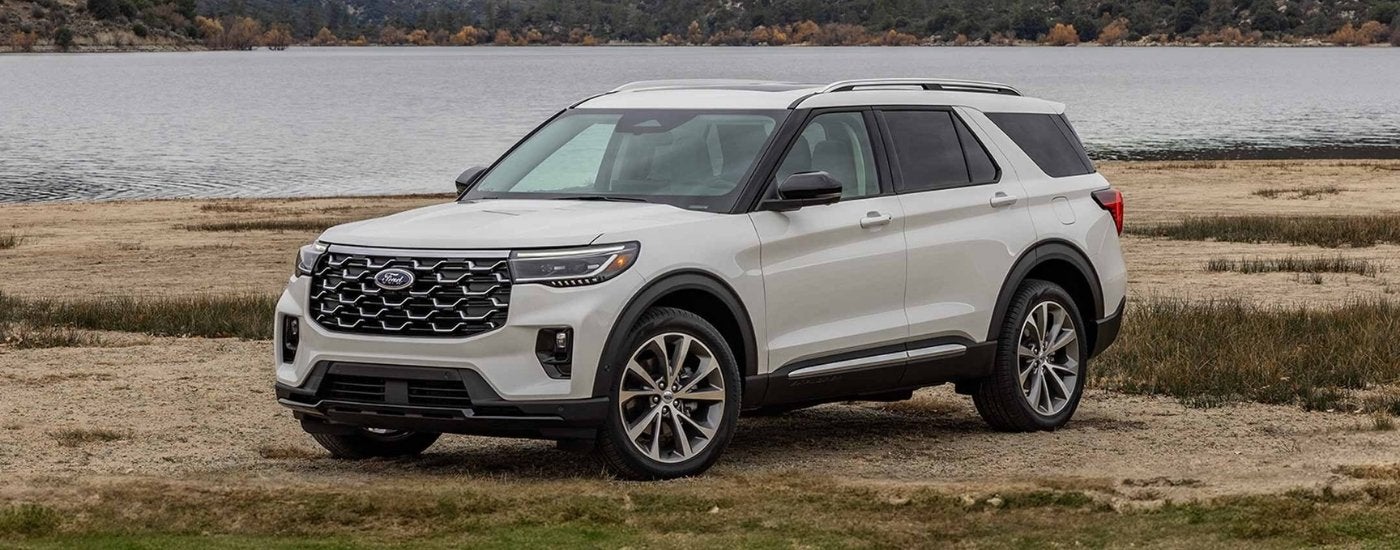 White 2025 Ford Explorer Platinum parked near a lake