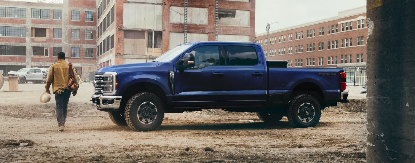 A blue 2026 Ford Super Duty F-250 Lariat parked on a construction site.